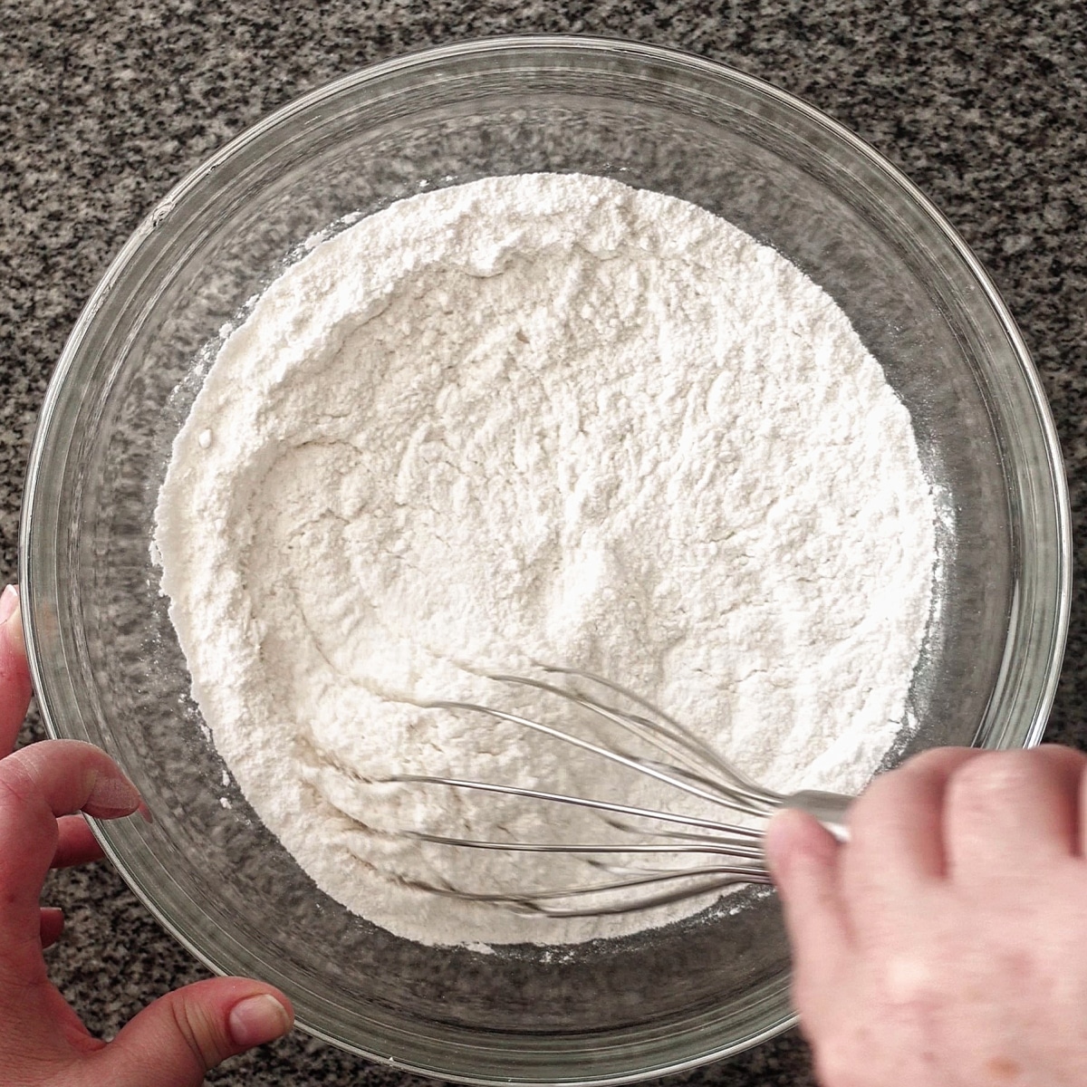 whisking dry ingredients in large glass bowl.