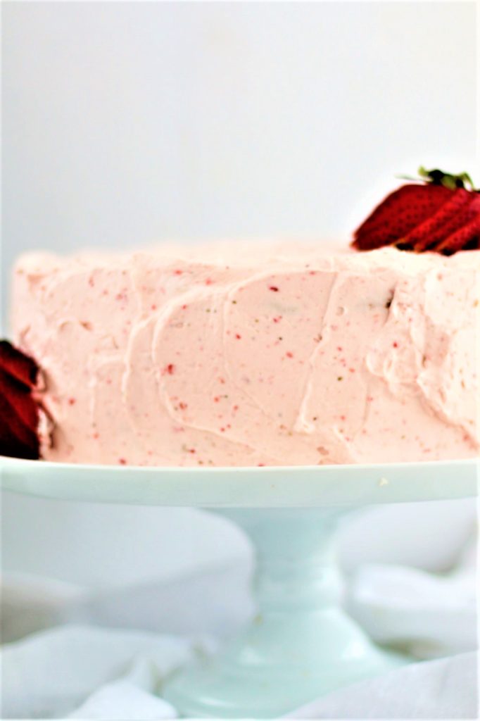 gluten free strawberry angel food cake on a white cake stand