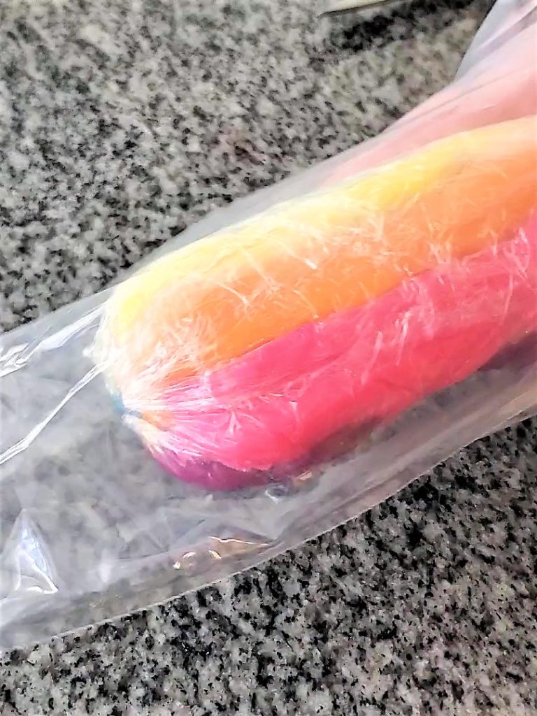 putting rainbow frosting into piping bag