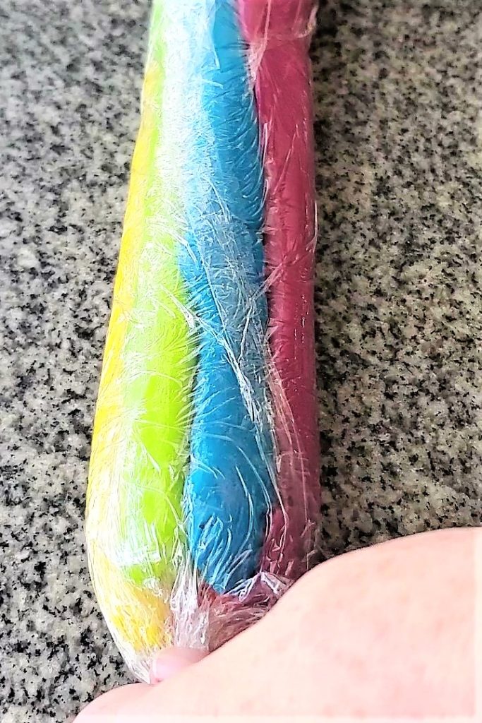 twisting rainbow frosting into plastic wrap