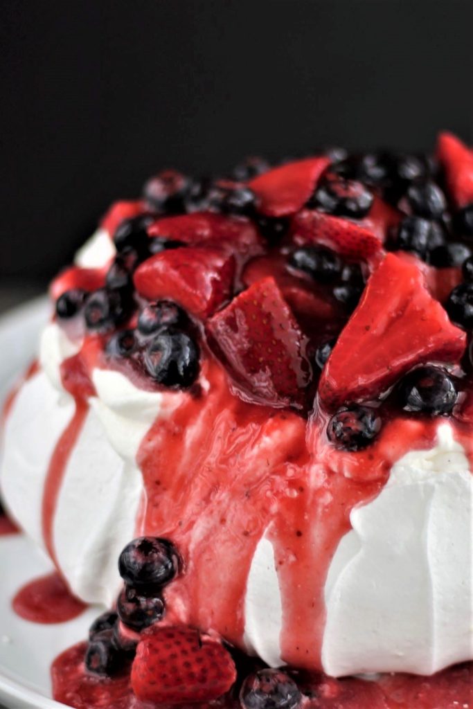 berry pavlova on white with black background