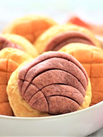 white bowl filled with conchas with orange and pink napkins surrounding
