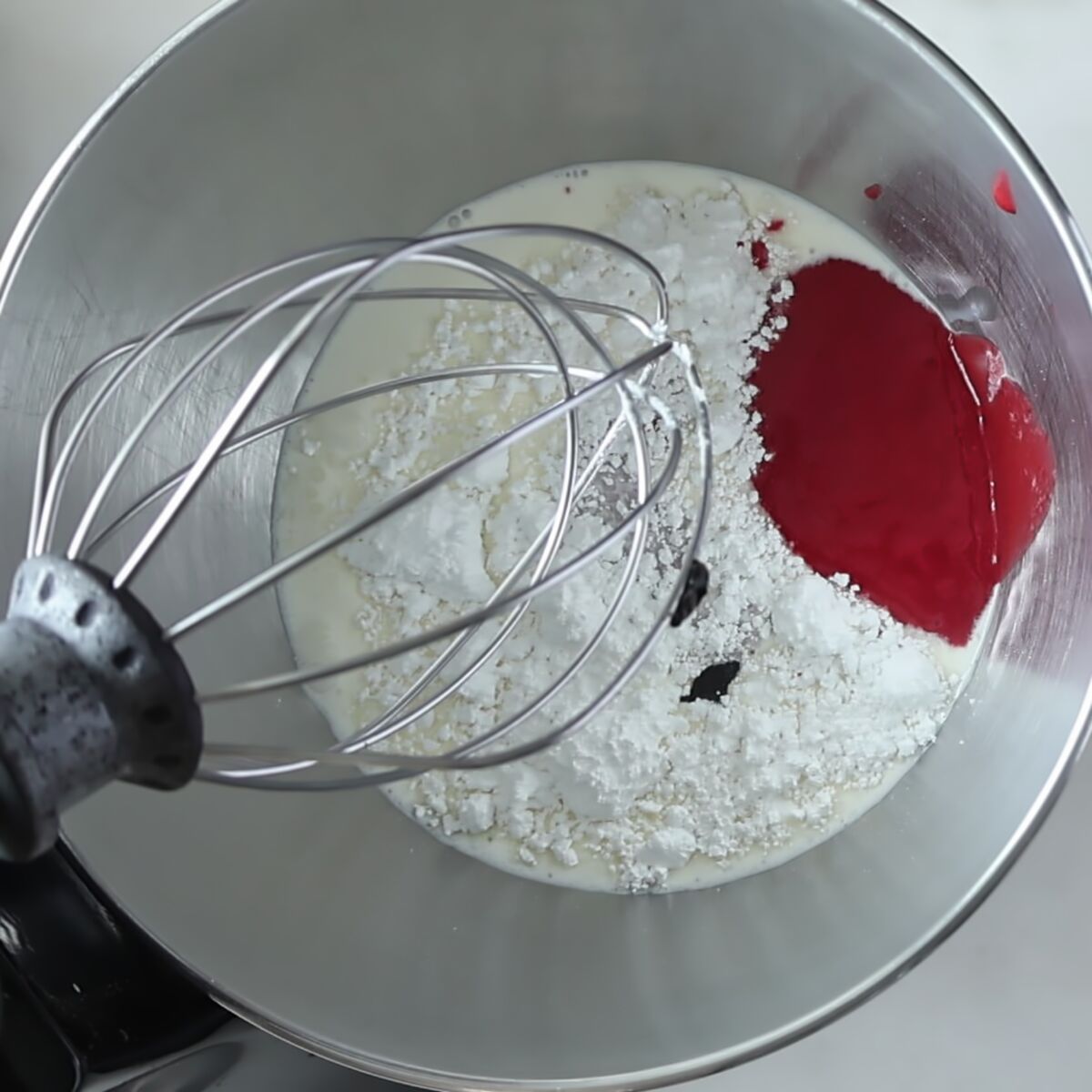 cream, strawberry powder, powdered sugar, and vanilla paste in mixer bowl.