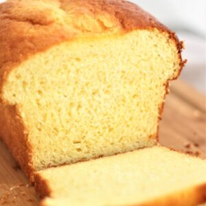 gluten free brioche loaf with a few slices cut on a wooden cutting board