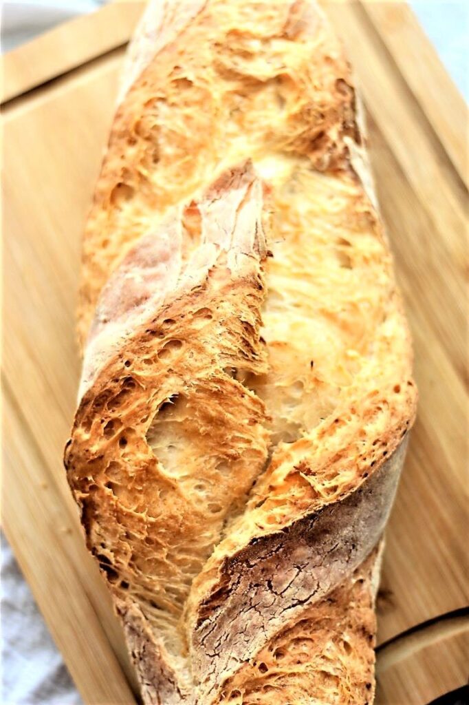 whole loaf of gf artisan bread on cutting board