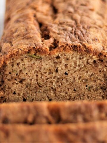 landscape view of loaf on white rectangular platter with a few slices cut