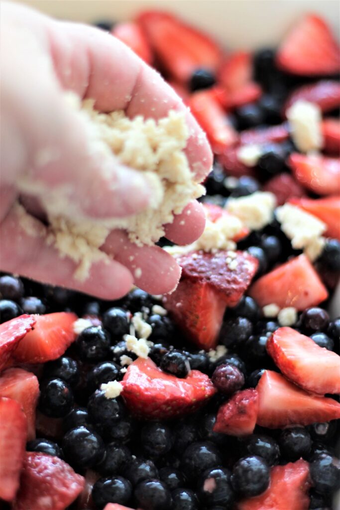 sprinkling crumble over fruit