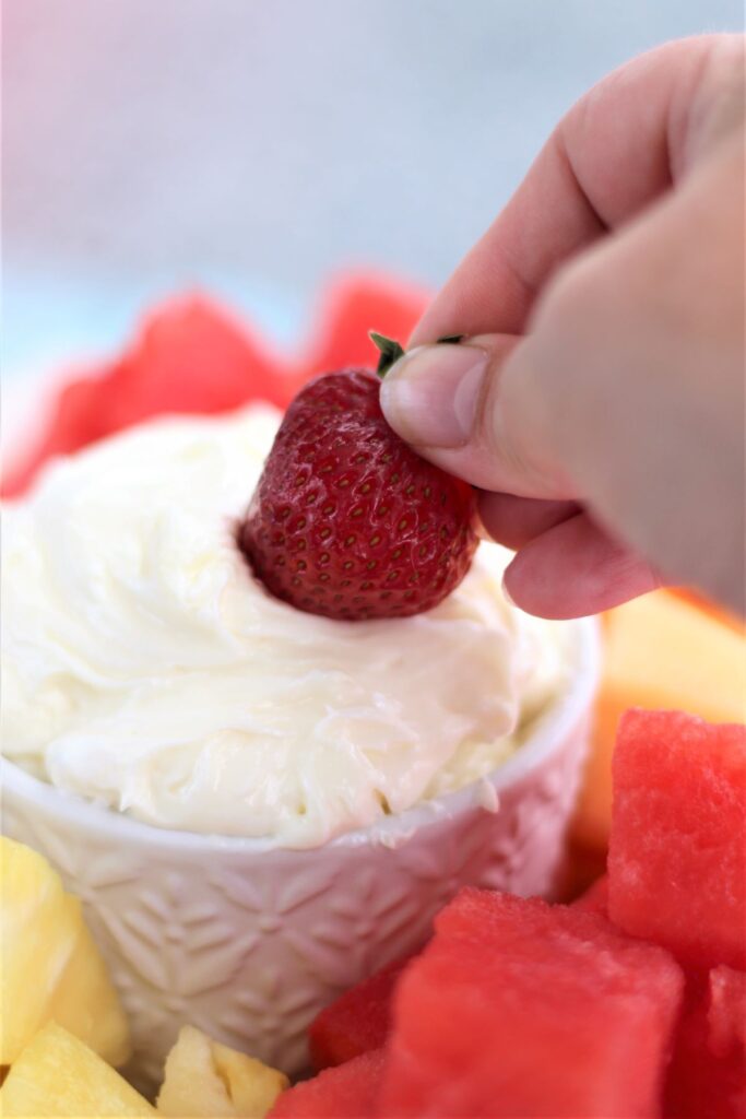 dipping strawberry into fruit dip