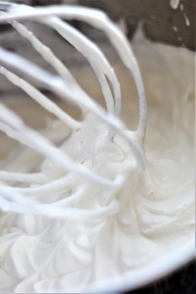 whipped cream in bowl with wire whisk
