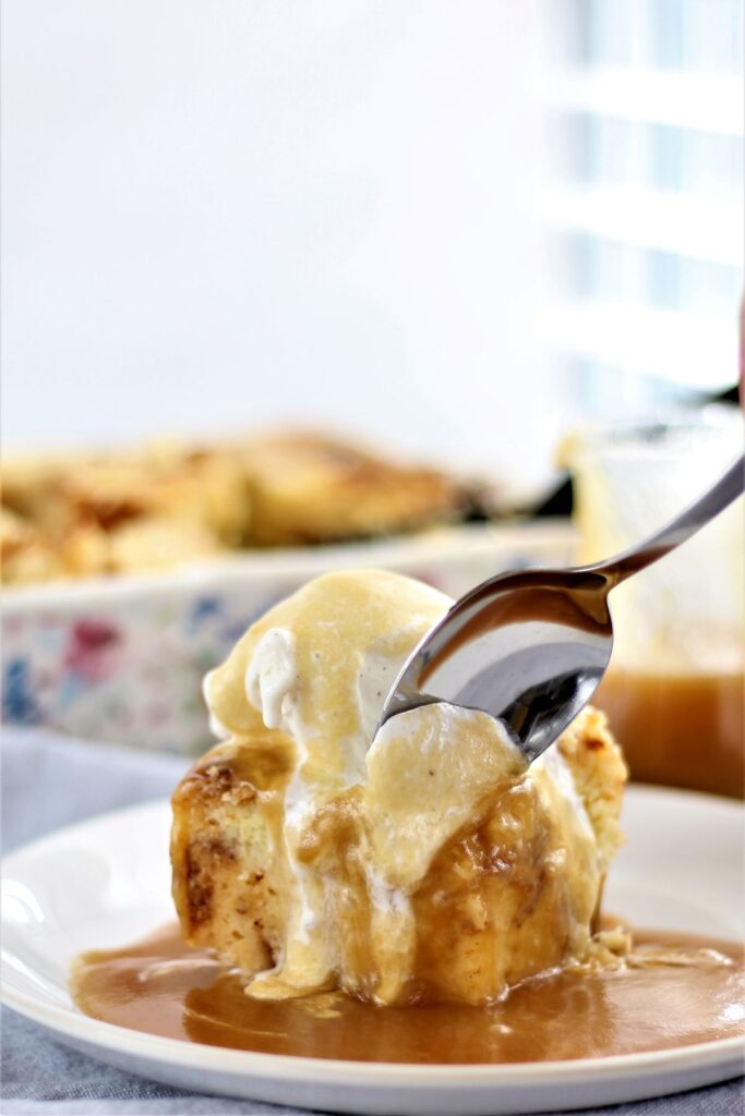 scooping a spoonful of bread pudding with vanilla ice cream