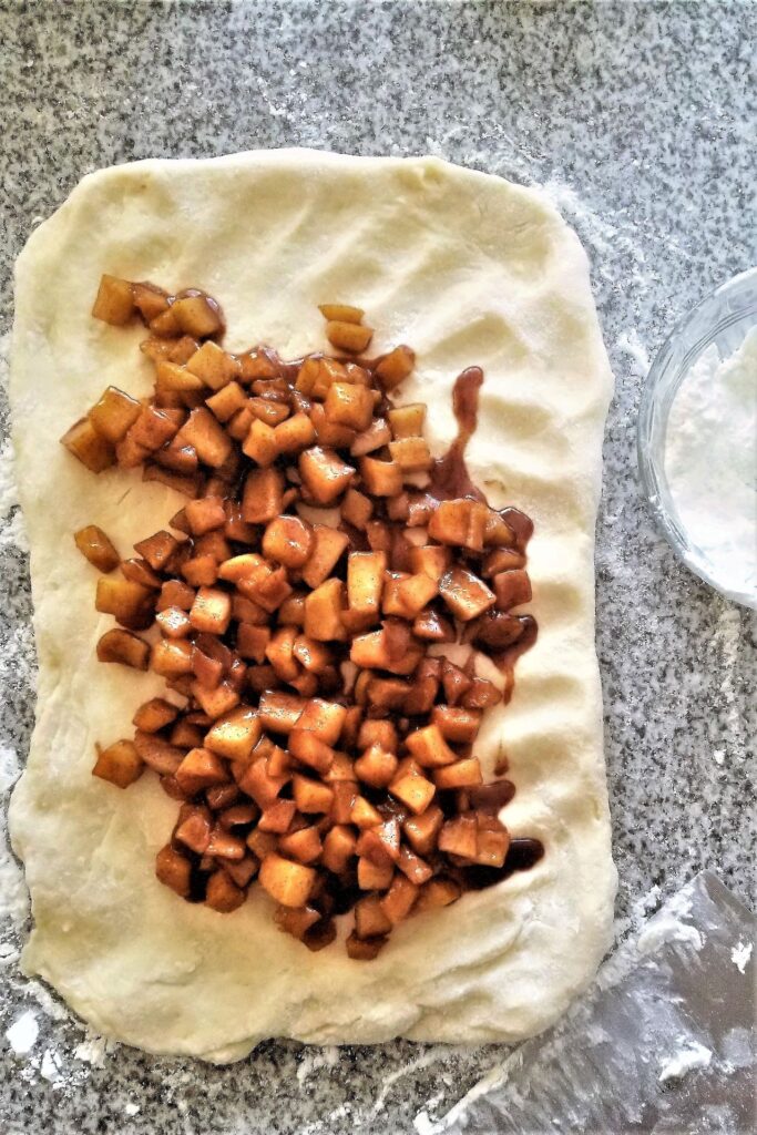 apples scattered over rolled dough