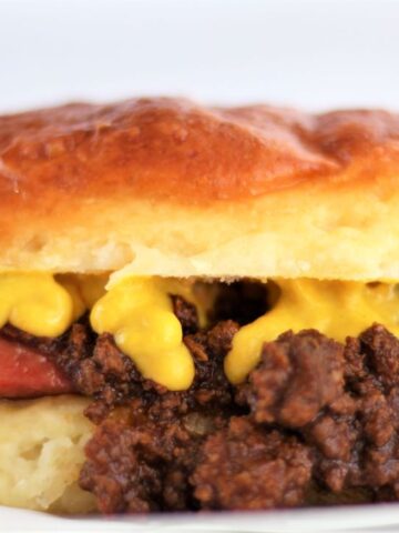 landscape view of a gluten free texas weiner on white parchment paper with yellow mustard