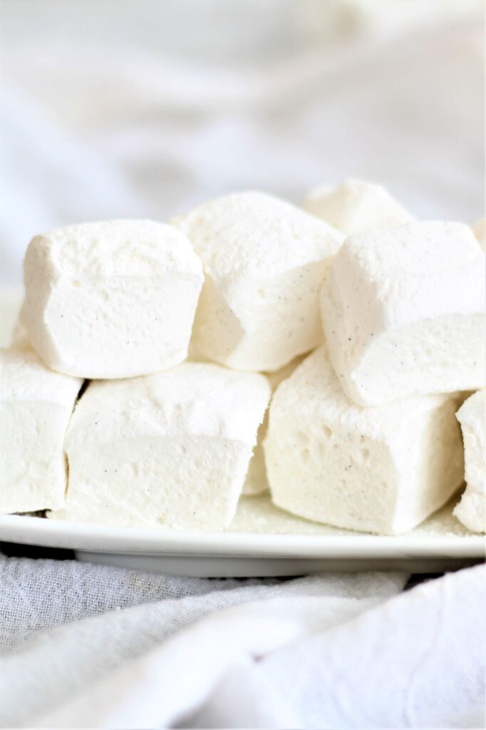 marshmallows stacked on white plate over white towel