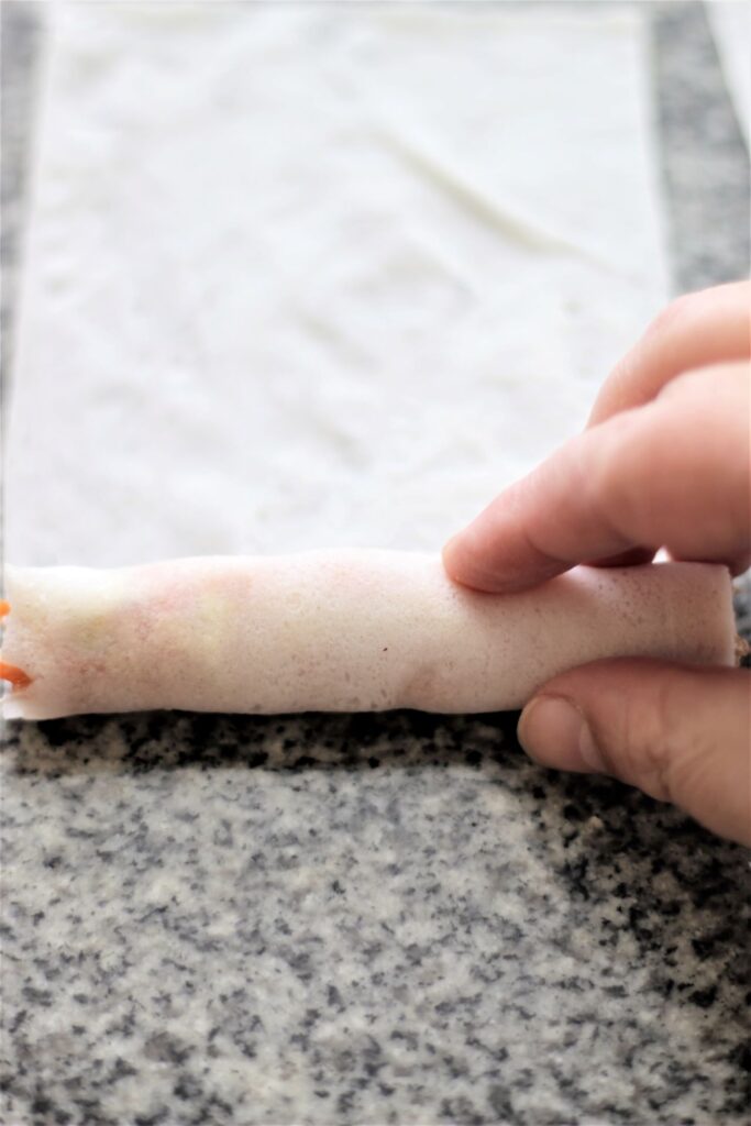 rolling up filling inside lumpia wrapper
