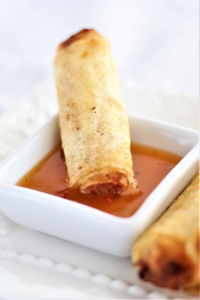 dipping gf lumpia into sweet and sour sauce