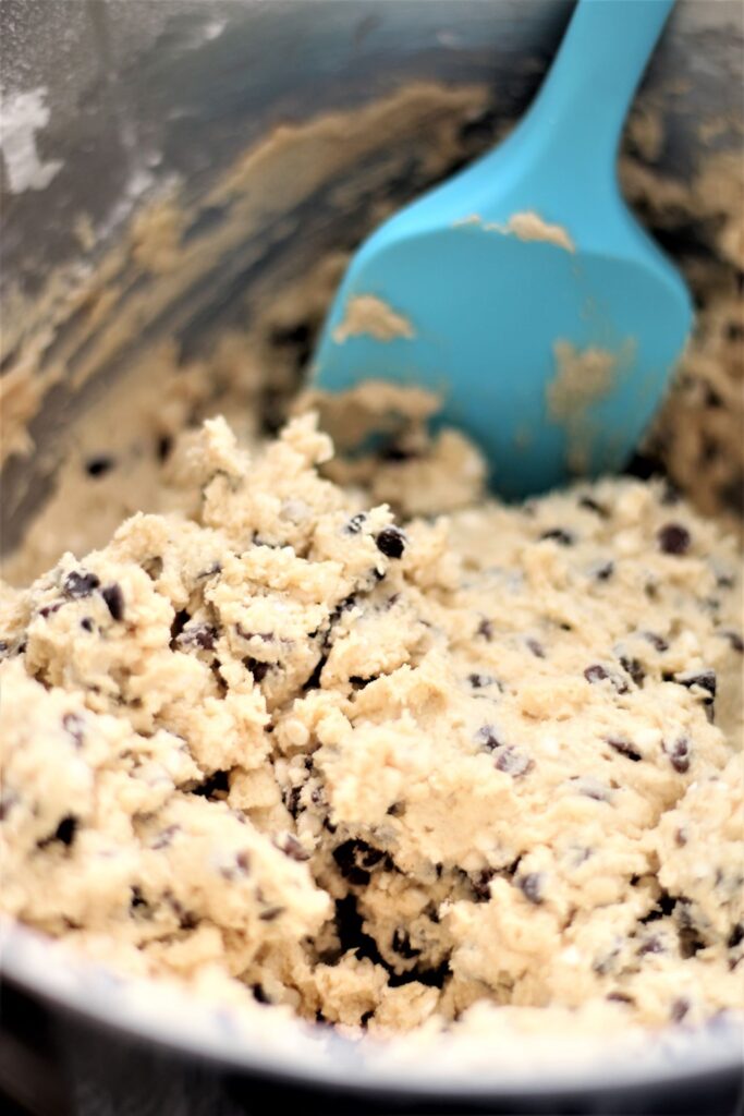 cookie dough mixed in bowl with blue spatula