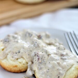 sausage gravy over biscuits on white plate