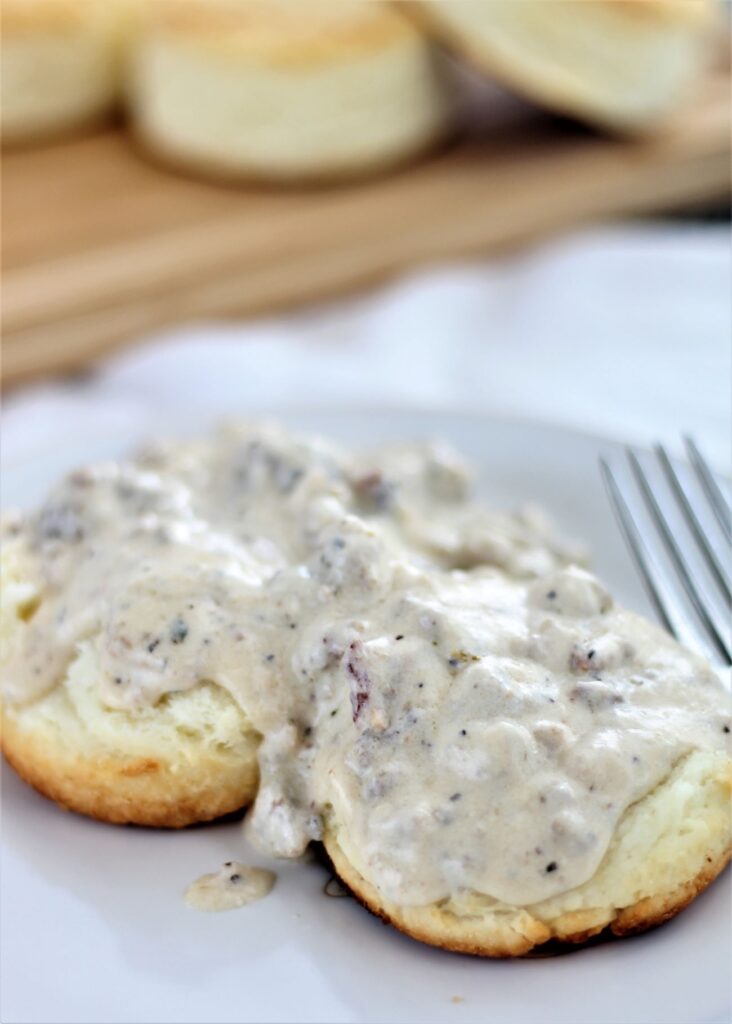 sausage gravy over biscuits on white plate