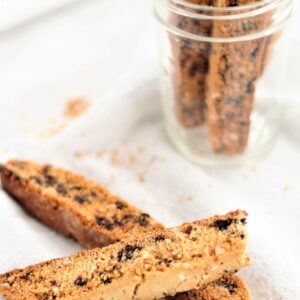 chocolate chip biscotti on white towel with crumbs all around