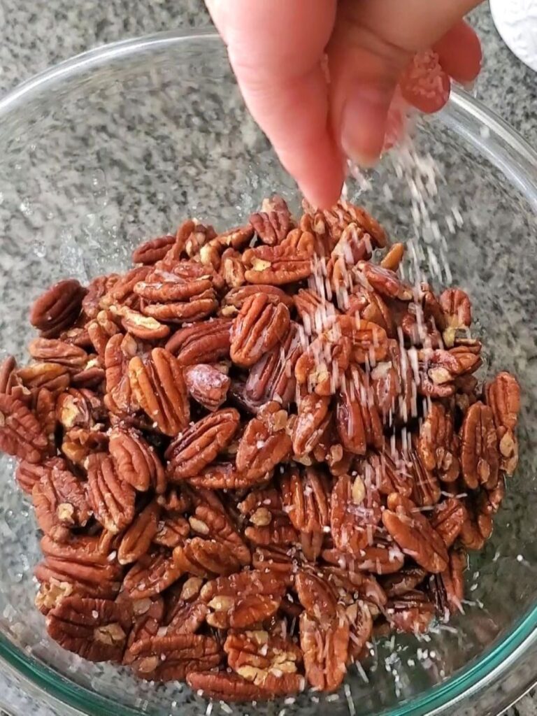 sprinkling salt over pecans