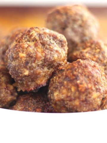 landscape view of meatballs stacked in a white bowl