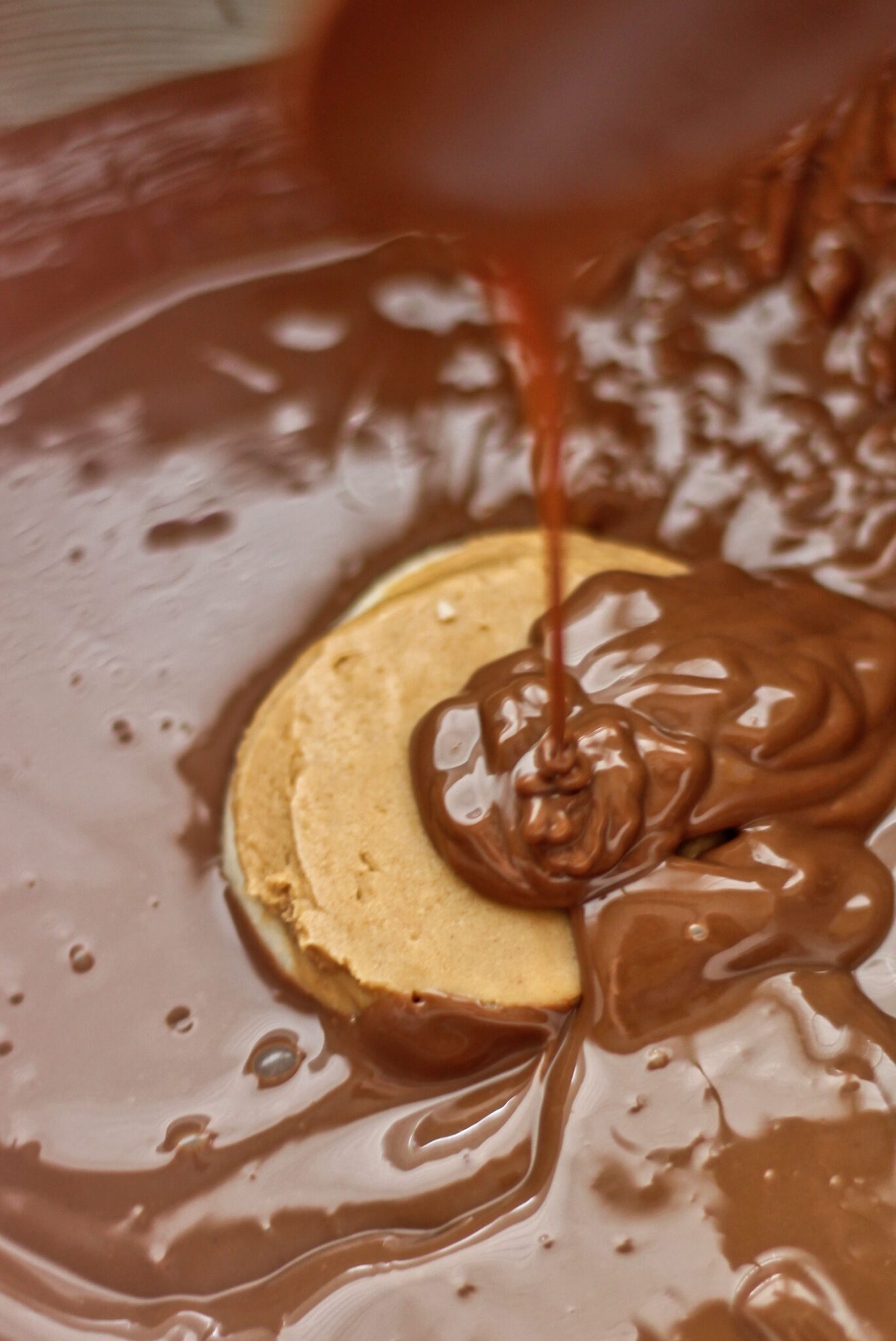 pouring chocolate over cookie