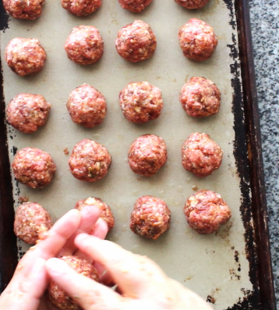 rolling meatballs and placing on baking sheet