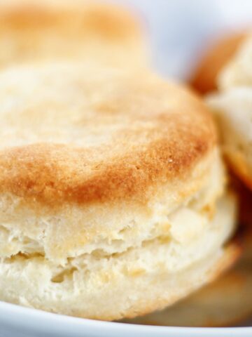 landscape view of gluten free cream biscuits stacked in white bowl