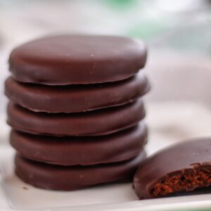 stack of thin mints on white square plate with one broken in half