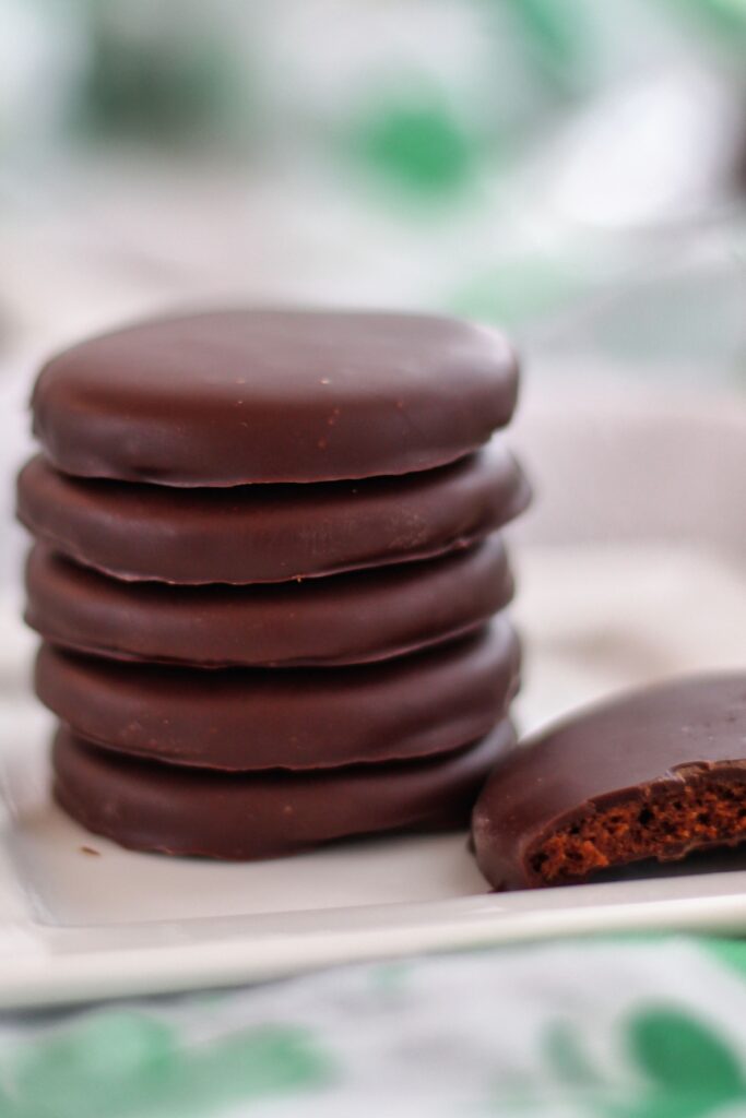 stack of thin mints on white square plate with one broken in half