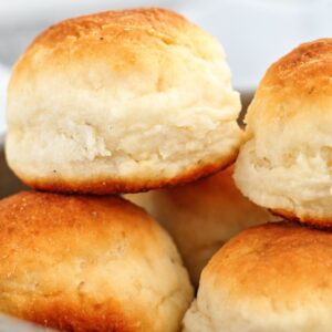 pillowy soft gluten free dinner rolls stacked on top of each other.