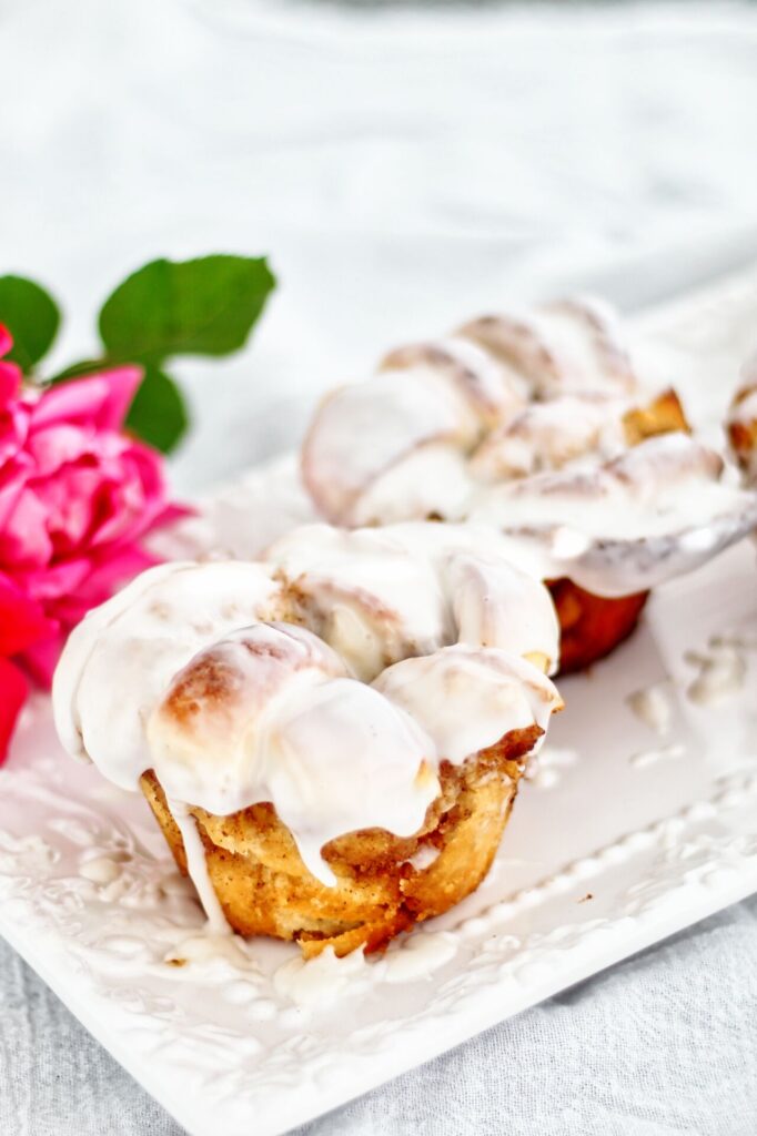 cinnamon knots on white rectangular platter with pink roses in background