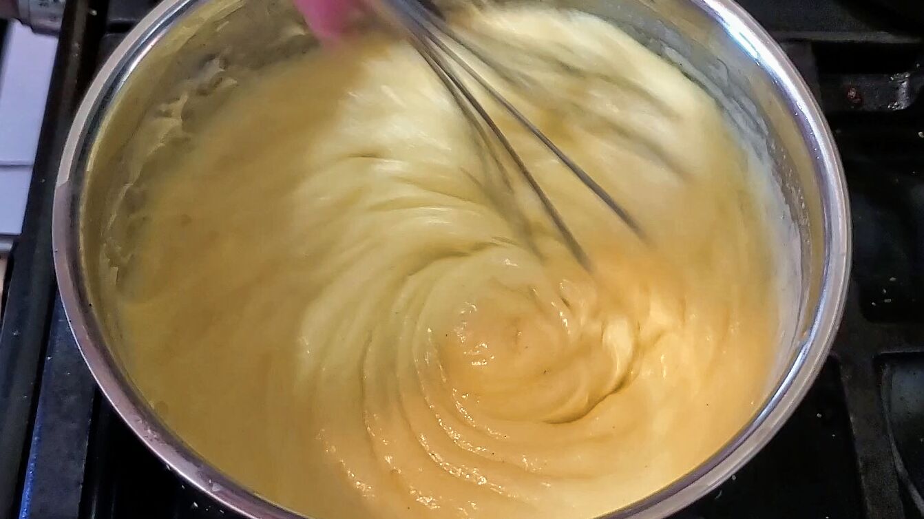 whisking pastry cream until thickened on stove