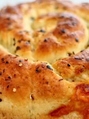 landscape view of whole spiral loaf of cheese bread on parchment