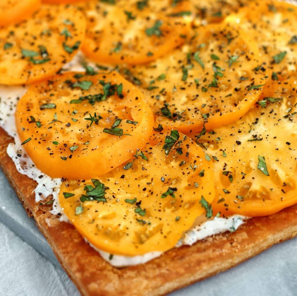 whole gf tomato tart with yellow tomatoes on marble tray