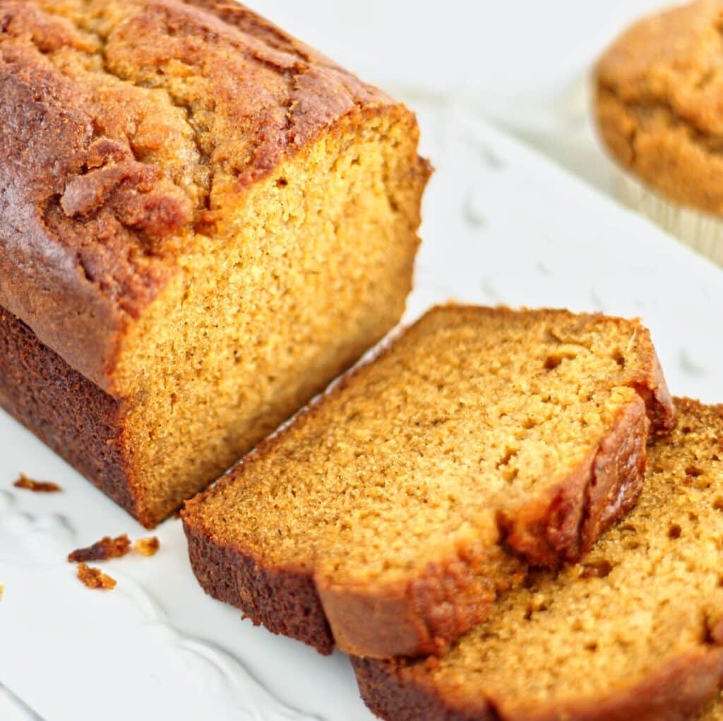 pumpkin loaf half sliced on a white rectangular platter