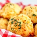 basket of gluten free cheddar bay biscuits lined with red checked napkin
