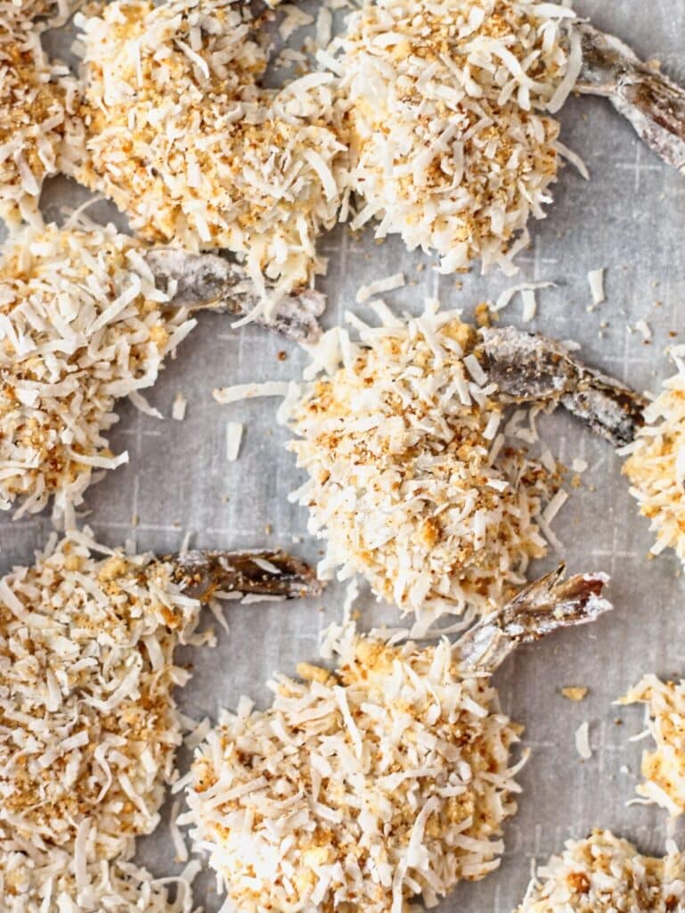 breaded shrimp on parchment-lined baking sheet.