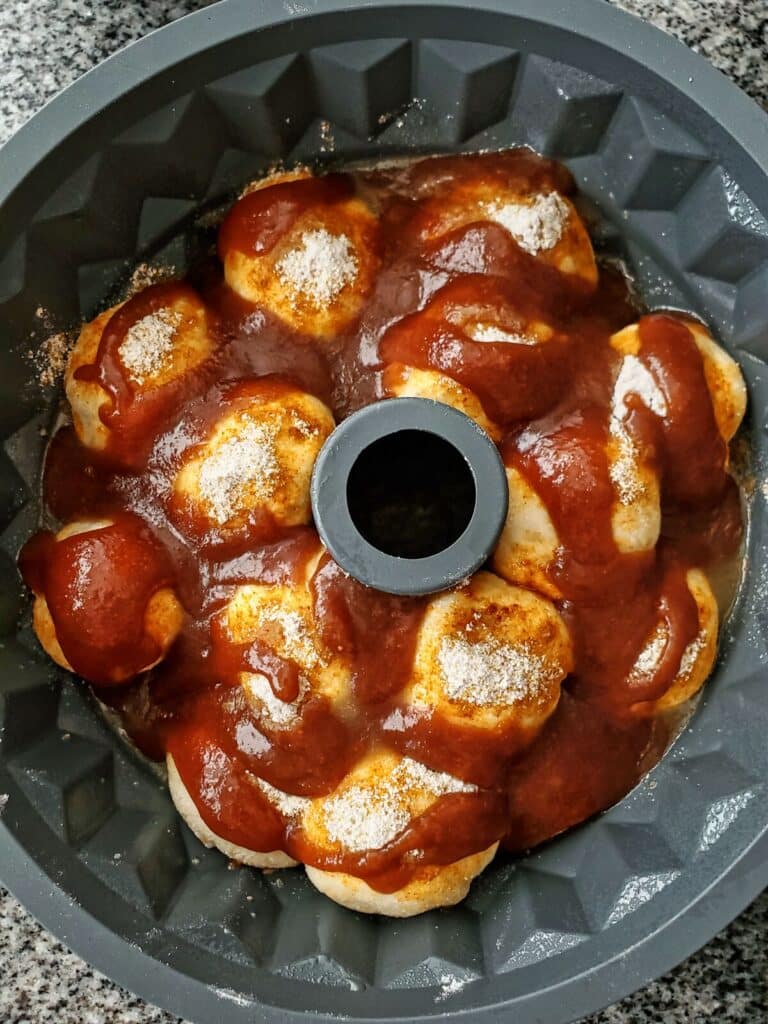 unrisen rolls in bundt pan covered in dry pudding mix and butterscotch sauce.