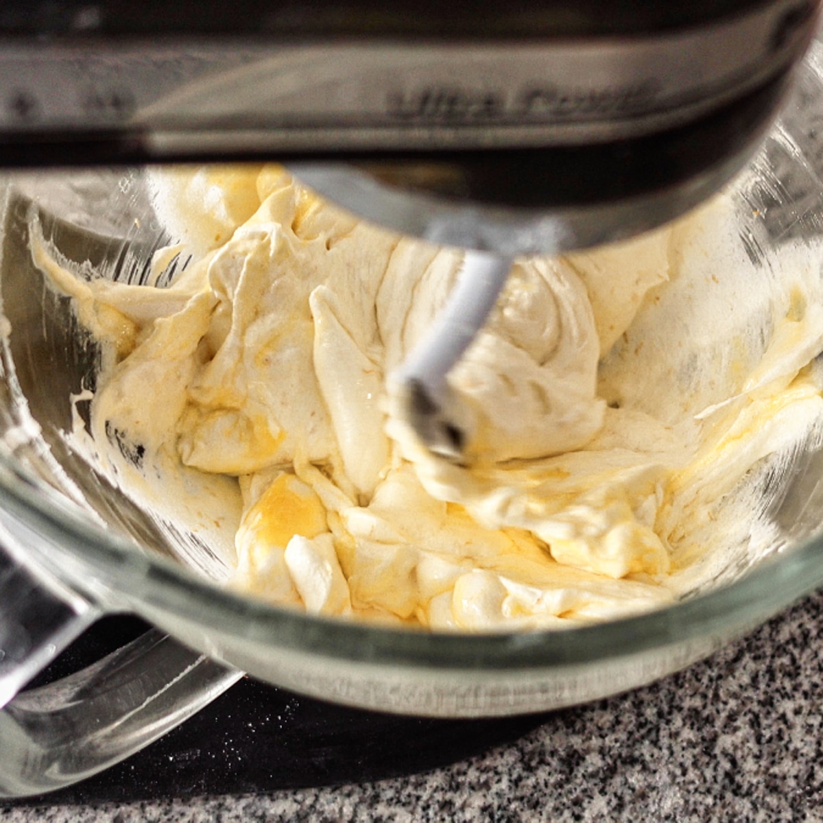 adding eggs to creamed butter and sugar and blending.