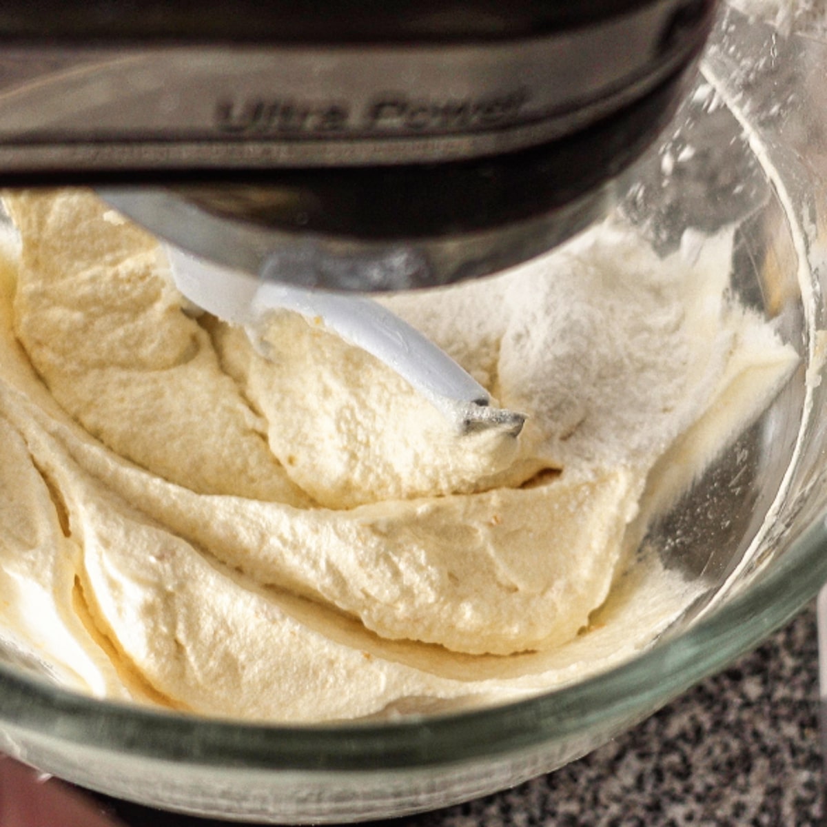 adding flour to batter in glass mixing bowl.