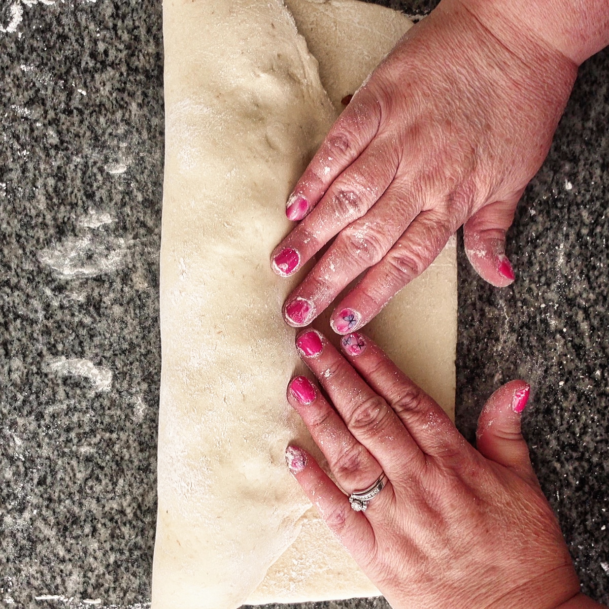folding the dough over the filling.