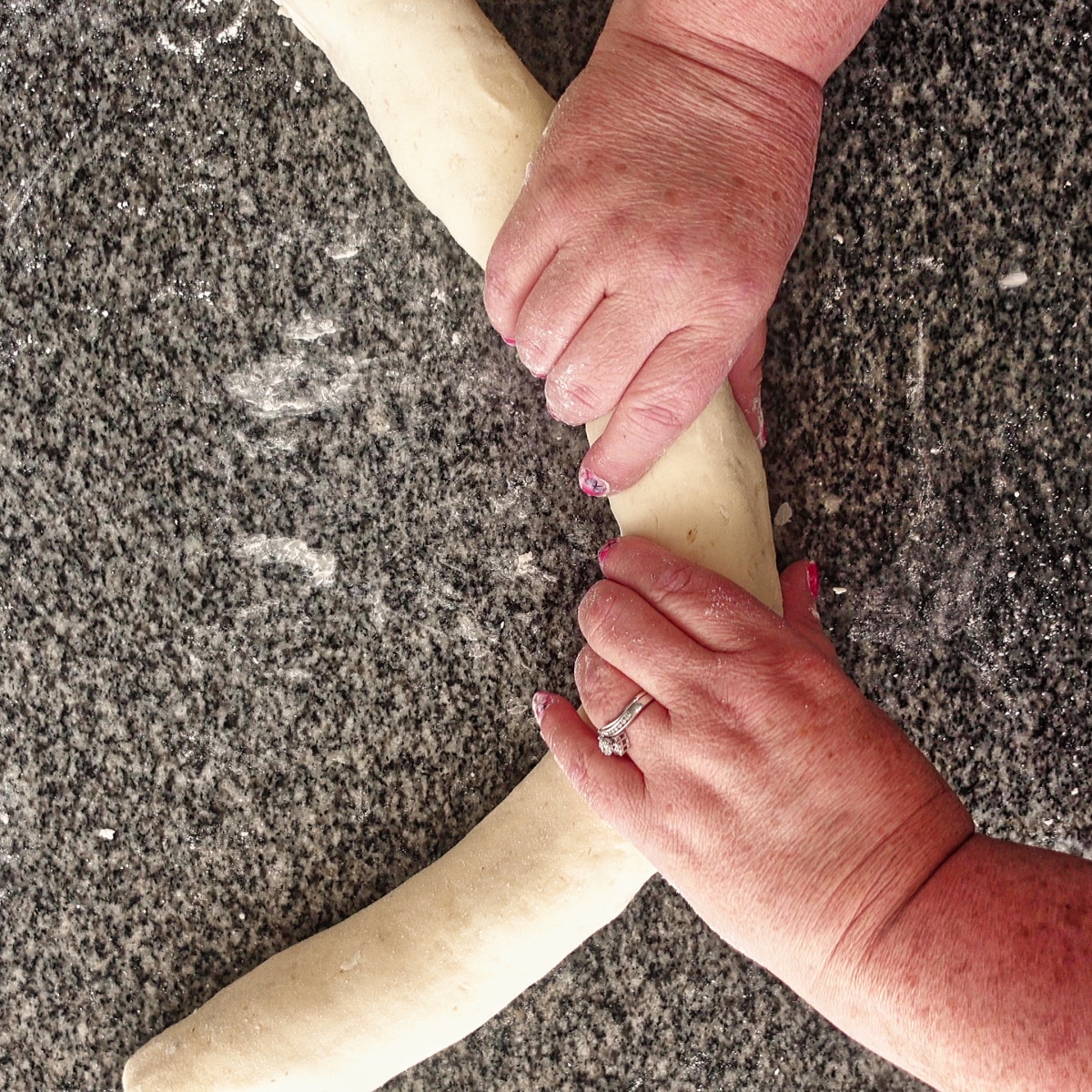 elongating the log of dough.