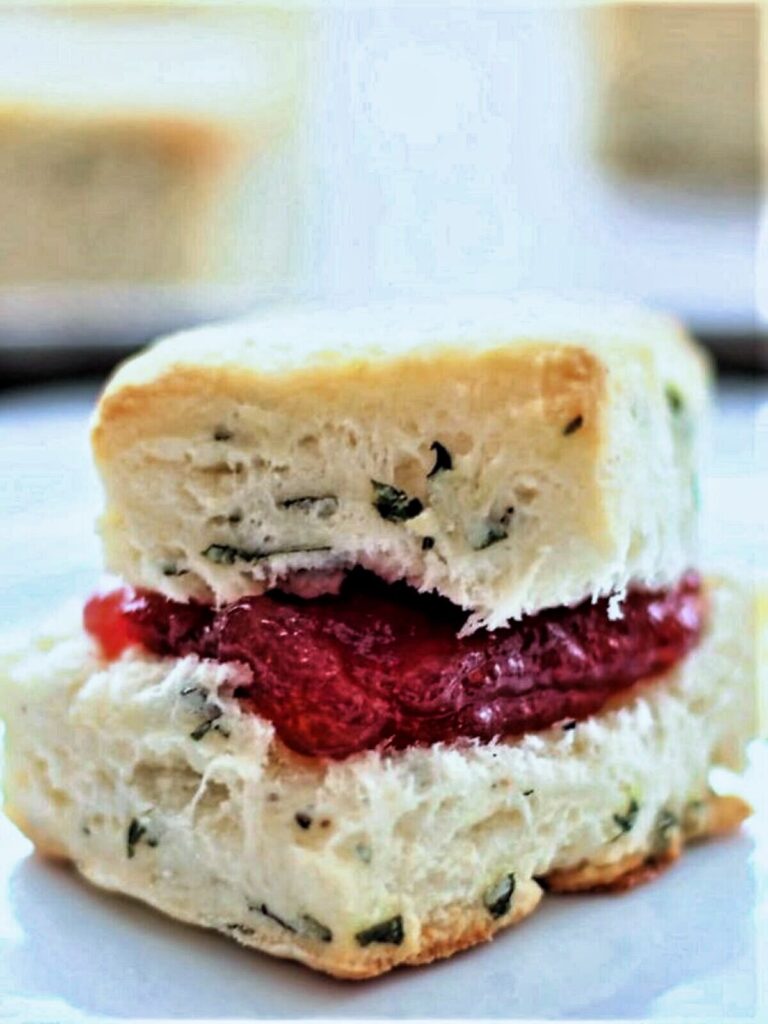 gf basil cream biscuit cut open and stuffed with strawberry jam.