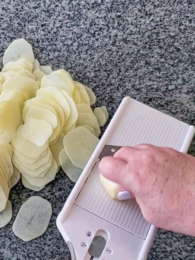 slicing potatoes with mandolin.
