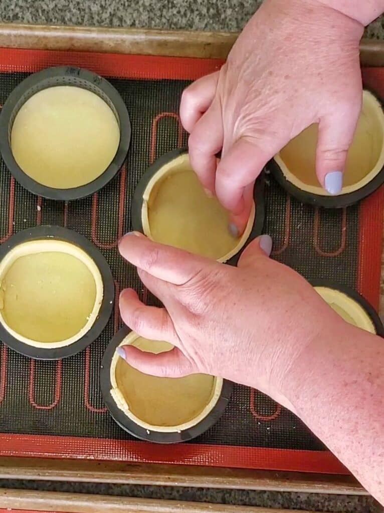 pressing the sides gently into the tart ring mold.