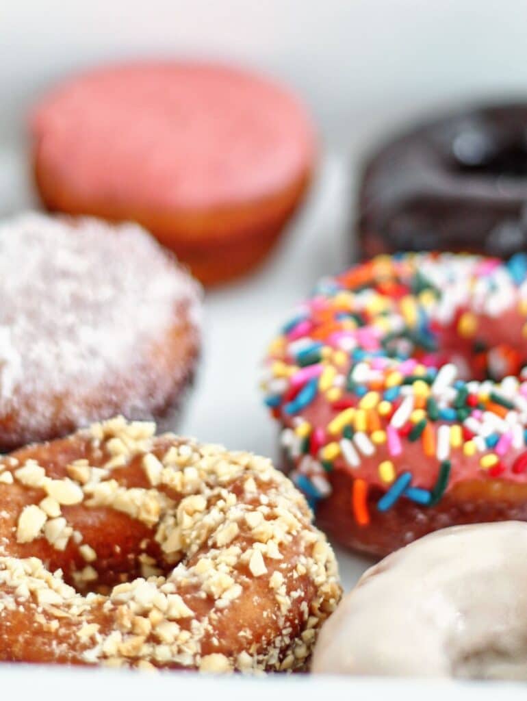 variety of gf donuts in white box.