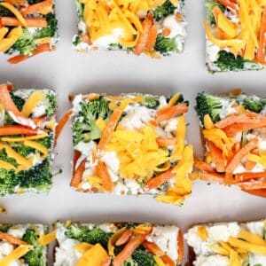 rows of gluten free veggie pizza squares on white plate.