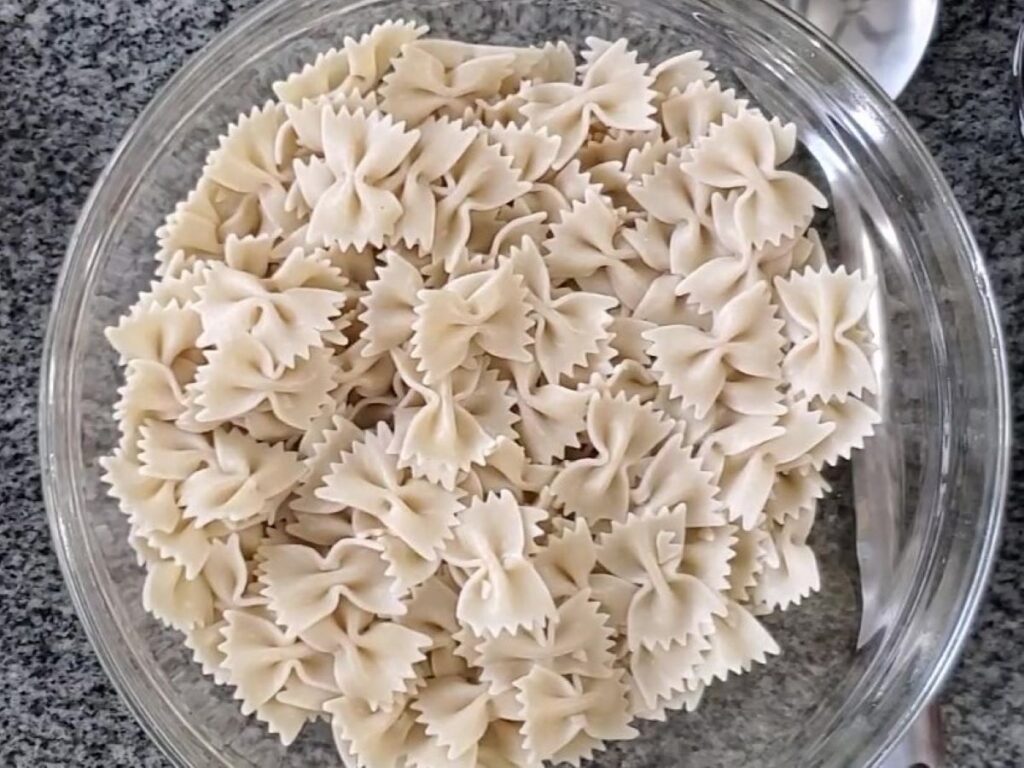 boiled gluten free farfalle/bow tie pasta in large glass bowl.