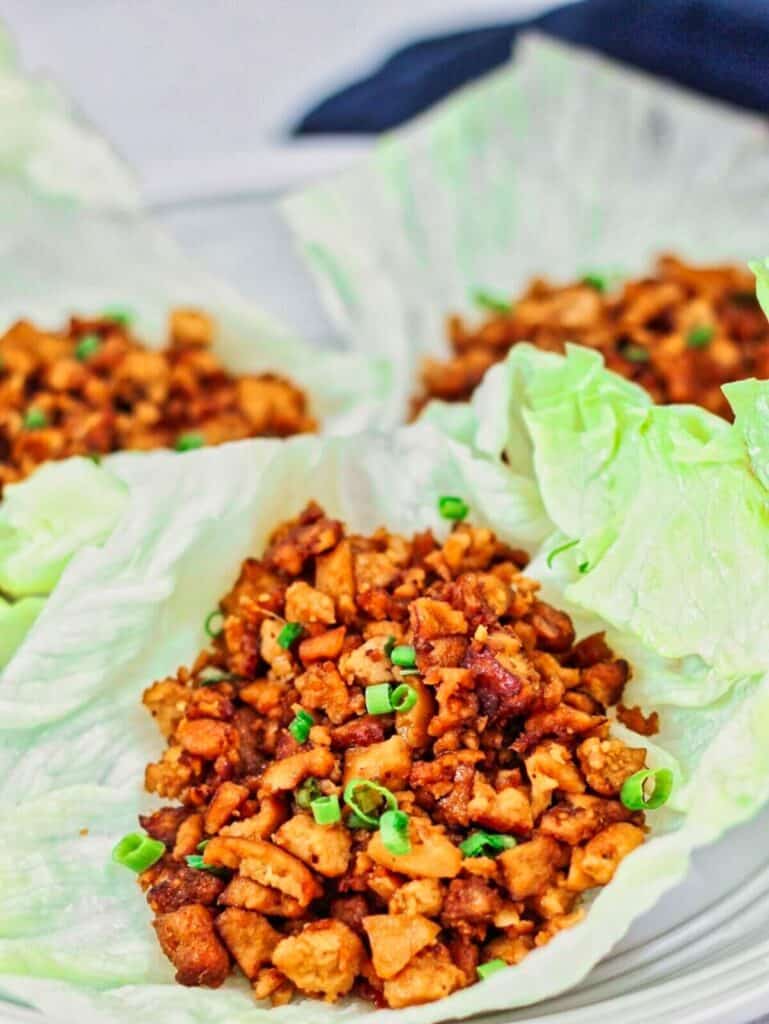 chicken or tofu lettuce wraps on white plate.